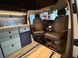 Twee pilotenstoelen op draaiplateaus, naar het leefgedeelte van de camper gedraaid