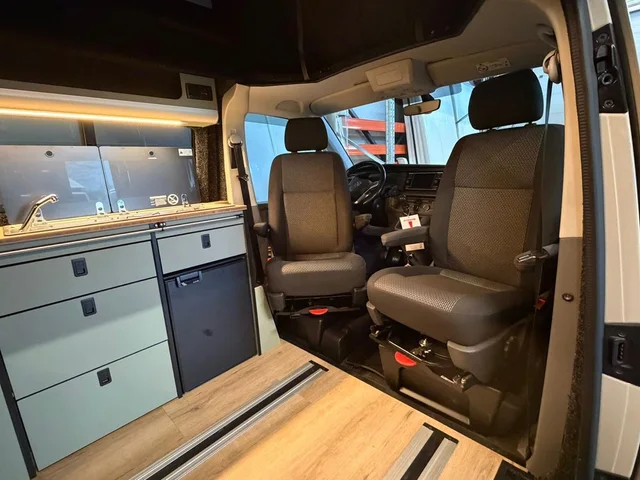 Twee pilotenstoelen op draaiplateaus, naar het leefgedeelte van de camper gedraaid
