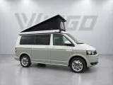 Groen-witte Volkswagen camper met witte luifel tegen de grijze VIGGO-achtergrond