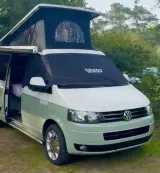 Volkswagen camper op de camping met een zwarte VIGGO verduisteringshoes om de cabine