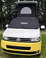 Zwarte VIGGO verduisteringshoes over de voorruit en zijramen van een geel-witte Volkswagen camper